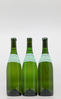 trois bouteilles de vin posées les unes à côté des autres sur une surface blanche