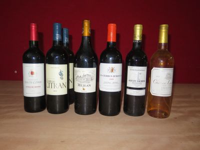 plusieurs bouteilles de vin sont alignées sur une table en bois