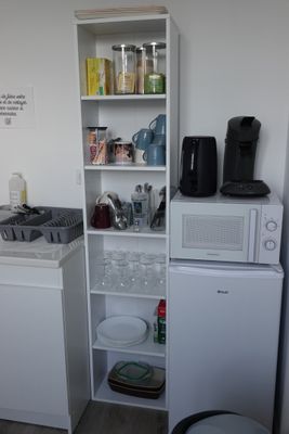 une petite cuisine équipée d'un micro-ondes, d'un réfrigérateur et d'un lave-vaisselle