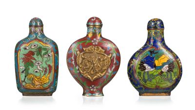 quatre vases de couleurs différentes sont alignés sur une surface blanche