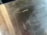 a close up of a metal surface with a bug on it