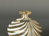 a white and gold vase sitting on a table