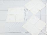 four pieces of white cloth laid out on a table