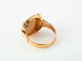 a close up of a gold ring with a stone in the middle