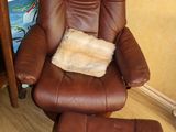 fauteuil inclinable en cuir marron et repose-pieds dans une pièce avec du parquet