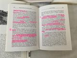 an open book with pink writing on it and a pair of scissors on top of it