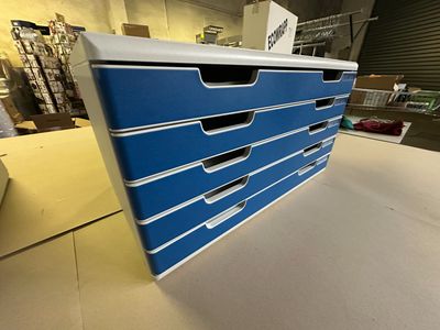 a close up of a stack of blue drawers on top of a table