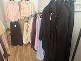 a photo of a clothing store with clothes hanging on racks
