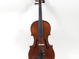 an old violin sitting on top of a white surface