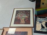 three framed paintings on the wall next to a clock