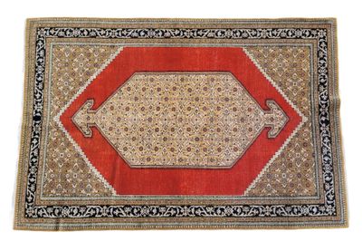 IRAN. TAPIS en laine quadrangulaire dans les tons rouges et …