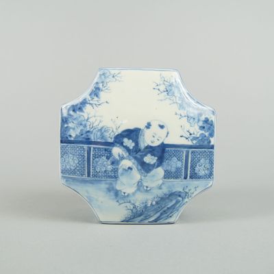 a blue and white vase with a woman and a dog on it