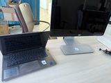 a laptop computer sitting on a desk next to a monitor
