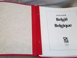 a book with a red cover sitting on a bed
