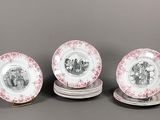four plates with pink and white designs on them sitting on a table