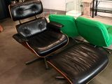 un fauteuil en cuir noir et un pouf vert dans un salon