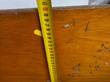 a measuring tape that is on the side of a wooden table