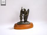 statue représentant un ange et un enfant, posée sur un socle en bois