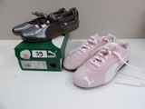 pair of pink puma shoes on a table next to a box of shoes