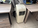 a small air conditioner sitting on a desk next to a computer