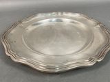 silver plate with scalloped edge on grey surface