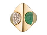 une image d'un gros plan d'une bague en or avec une pierre verte