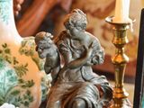une table sur laquelle se trouvent un vase, une bougie, un cadre et une photo