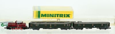 un petit train miniature posé à côté d'un paquet de cigarettes