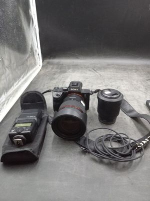 un appareil photo, un objectif, un étui pour appareil photo et un appareil photo posé sur une table