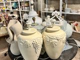many vases that are sitting on a table in a room