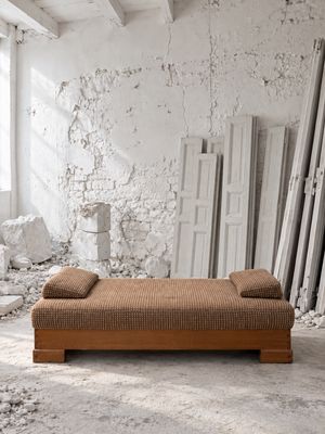 une photo d'un lit dans une chambre, avec un mur en arrière-plan
