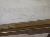 a marble top desk with brass hardware on it