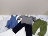 trois vêtements disposés sur une table blanche
