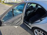 a silver car with its door open in a parking lot