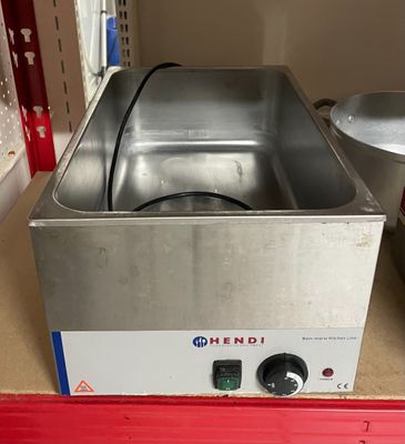 une photo d'une friteuse en acier inoxydable posée sur un plan de travail