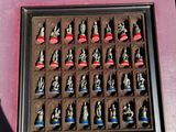 a shadow of a person standing next to a box of chess pieces