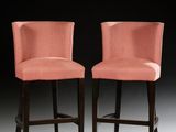 pair of pink upholstered bar stools with black legs
