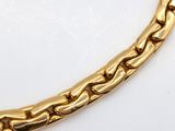 a close up of a gold chain on a white surface