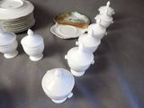 a lot of white dishes and cups on the table