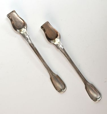 une paire d'ustensiles plaqués argent posés sur un fond blanc