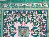 a green and white scarf with a picture of birds on it
