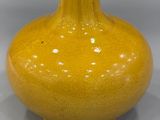 a yellow vase that is sitting on a table