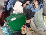 a pile of clothes that is sitting on a bed