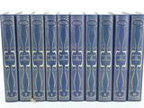 six blue books lined up in rows on a white surface