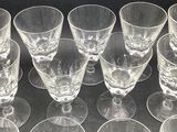 six clear wine glasses sitting on top of a table next to each other