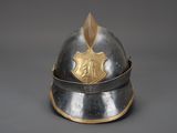 an old helmet with a shield on top of it on a gray surface