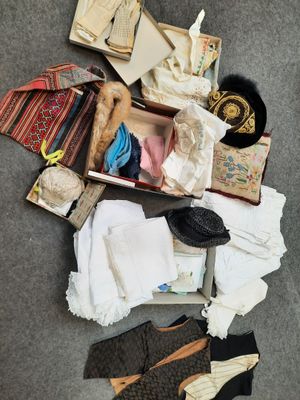 une valise remplie de vêtements et de chaussures posée par terre