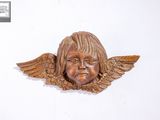 une sculpture en bois représentant un enfant avec des ailes sur la tête