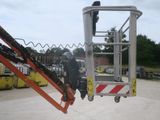 a picture of a man standing on a lift in a parking lot
