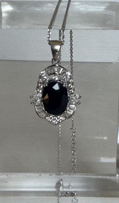 un collier orné d'une pierre noire suspendue à une chaîne